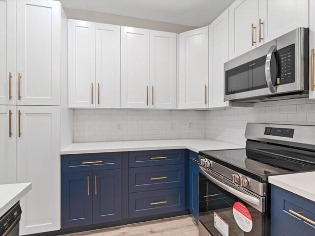 5702 Elysian St, Houston, TX 77009 - kitchen featuring appliances with stainless steel finishes, blue cabinets, light countertops, and white cabinetry