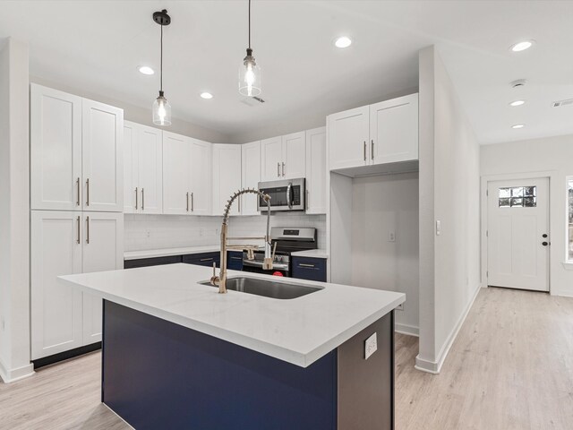 5702 Elysian St, Houston, TX 77009 - kitchen featuring stainless steel microwave, tasteful backsplash, light wood-type flooring, white cabinetry, and recessed lighting