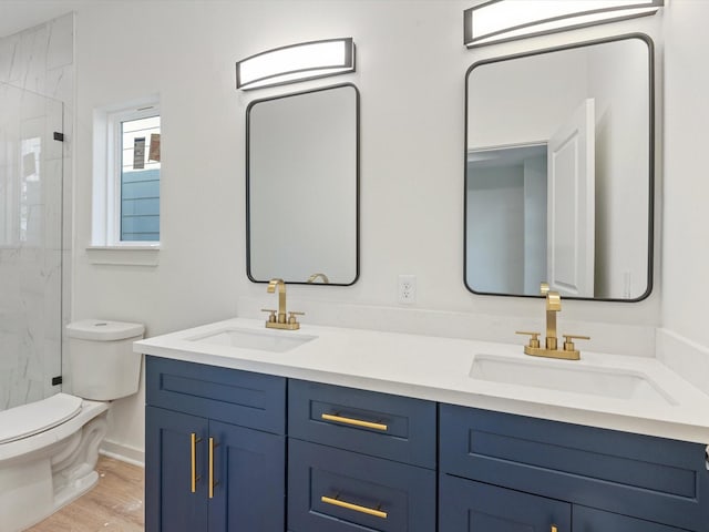 5702 Elysian St, Houston, TX 77009 - bathroom featuring a marble finish shower, double vanity, and wood finished floors