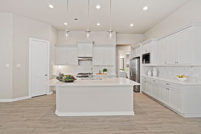 1919 Waters Branch Dr, Missouri City, TX 77459 - kitchen with stainless steel appliances, a center island with sink, backsplash, light countertops, and recessed lighting