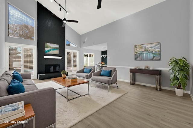 15810 Parksley Dr, Houston, TX 77059 - living area with high vaulted ceiling, a ceiling fan, light wood-style floors, track lighting, and a brick fireplace