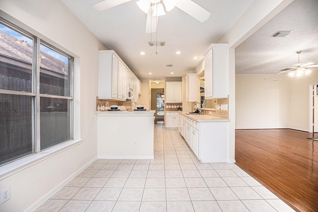 1726 Roaring Springs Ln, Seabrook, TX 77586 - kitchen featuring a ceiling fan, light countertops, open floor plan, light tile patterned flooring, and white cabinets