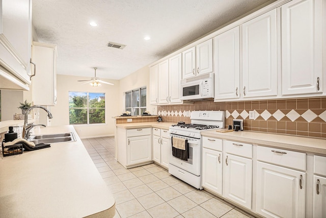 1726 Roaring Springs Ln, Seabrook, TX 77586 - kitchen featuring white appliances, light tile patterned floors, light countertops, tasteful backsplash, and ceiling fan