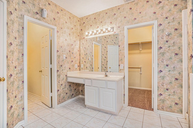 1726 Roaring Springs Ln, Seabrook, TX 77586 - bathroom with tile patterned floors, a spacious closet, vanity, and wallpapered walls