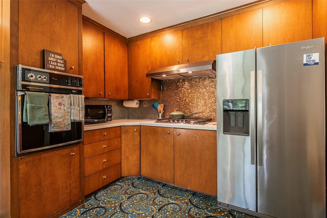 1208 15th Ave N, Texas City, TX 77590 - kitchen with black appliances, under cabinet range hood, decorative backsplash, brown cabinets, and light countertops