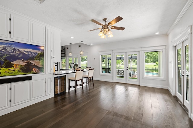 34310 High Point Dr, Magnolia, TX 77355 - kitchen with french doors, beverage cooler, white cabinets, a textured ceiling, and dark wood finished floors