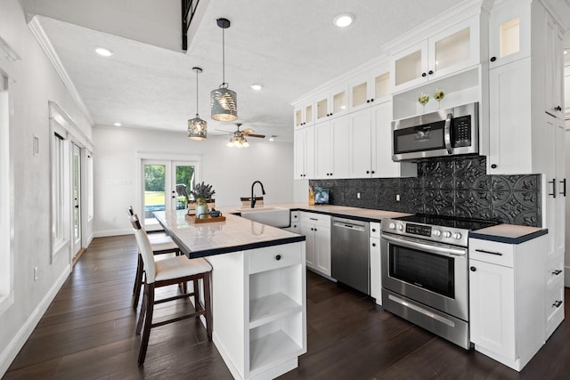 34310 High Point Dr, Magnolia, TX 77355 - kitchen featuring stainless steel appliances, open shelves, backsplash, a peninsula, and french doors