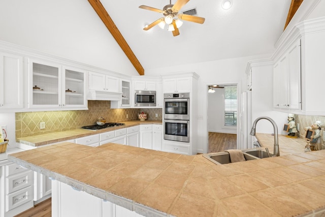 34310 High Point Dr, Magnolia, TX 77355 - kitchen featuring appliances with stainless steel finishes, a ceiling fan, white cabinetry, and glass insert cabinets