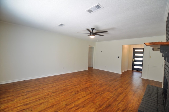 154 Wood Manor Ln, Sour Lake, TX 77659 - unfurnished living room with dark wood-type flooring, a fireplace, ceiling fan, and a textured ceiling