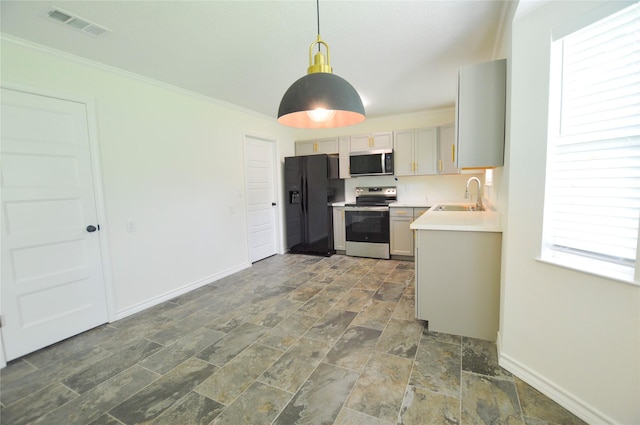 154 Wood Manor Ln, Sour Lake, TX 77659 - kitchen with stainless steel appliances, dark stone finish flooring, light countertops, decorative light fixtures, and ornamental molding