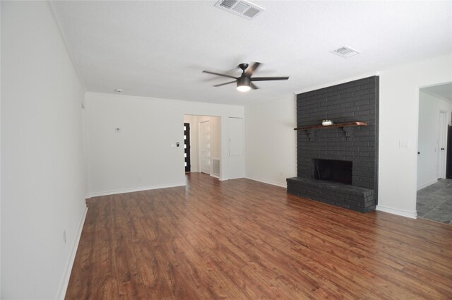 154 Wood Manor Ln, Sour Lake, TX 77659 - unfurnished living room with wood finished floors, a ceiling fan, and a fireplace