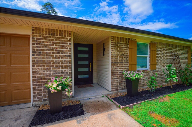 154 Wood Manor Ln, Sour Lake, TX 77659 - property entrance with brick siding and an attached garage