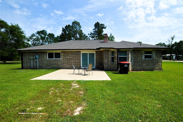 154 Wood Manor Ln, Sour Lake, TX 77659 - back of house featuring brick siding, a patio, a chimney, and a lawn