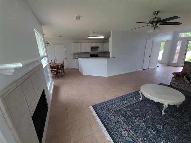 6322 Northland Dr, Houston, TX 77084 - living room with light tile patterned floors, ceiling fan, and a fireplace