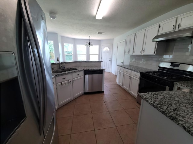 6322 Northland Dr, Houston, TX 77084 - kitchen with stainless steel appliances, under cabinet range hood, white cabinets, tasteful backsplash, and a textured ceiling