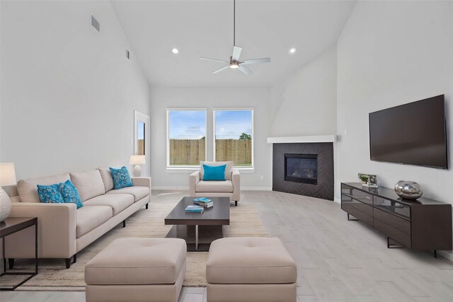373 Spruce Oak Ln, Waller, TX 77484 - living room with ceiling fan, high vaulted ceiling, light wood-style floors, a glass covered fireplace, and recessed lighting