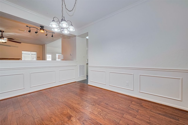 10818 Kleberg Place Dr, Houston, TX 77064 - unfurnished dining area with ornamental molding, a chandelier, wood finished floors, a decorative wall, and a ceiling fan