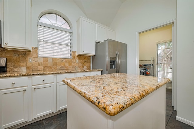 10818 Kleberg Place Dr, Houston, TX 77064 - kitchen featuring stainless steel refrigerator with ice dispenser, healthy amount of natural light, tasteful backsplash, white cabinetry, and vaulted ceiling