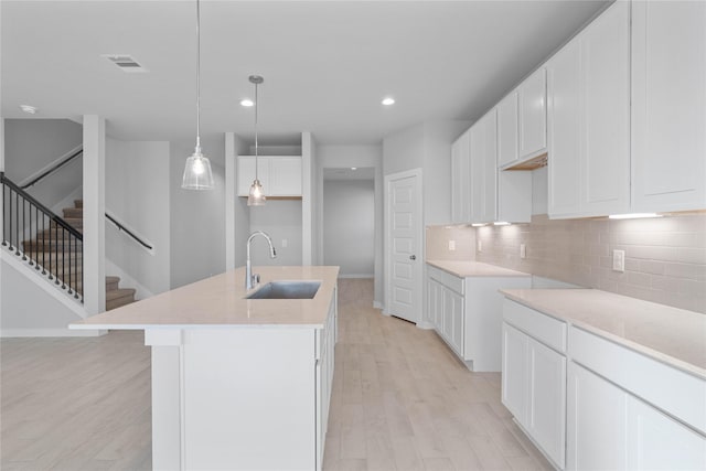 304 E Tranquil Fields Ln, Waller, TX 77484 - kitchen featuring decorative backsplash, recessed lighting, light wood-type flooring, an island with sink, and white cabinetry
