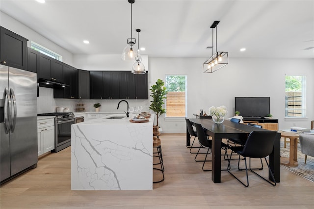 4110 Cortlandt St, Houston, TX 77018 - kitchen with stainless steel appliances, under cabinet range hood, recessed lighting, light stone countertops, and light wood-style flooring