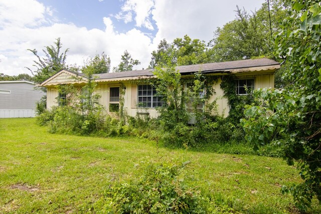 907 Linia Alfred St, Cleveland, TX 77327 - view of front of home with a front yard and board and batten siding