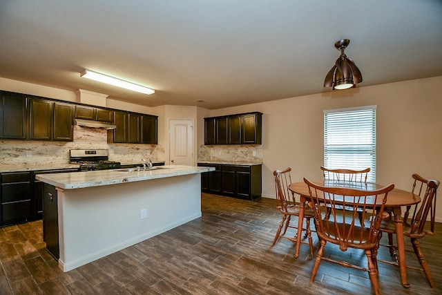 2026 Naplechase Crest Dr, Spring, TX 77373 - kitchen featuring gas stove, decorative backsplash, dark wood-style floors, a kitchen island with sink, and dark brown cabinets