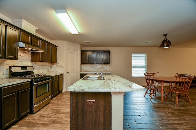 2026 Naplechase Crest Dr, Spring, TX 77373 - kitchen featuring stainless steel range with gas stovetop, under cabinet range hood, dark brown cabinets, decorative backsplash, and dark wood-style flooring