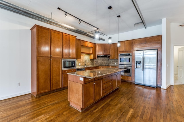 1616 Fountain View Dr Unit 202, Houston, TX 77057 - kitchen featuring appliances with stainless steel finishes, dark wood-style flooring, backsplash, track lighting, and dark stone countertops