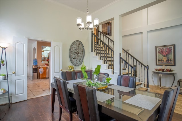 9434 Barretts Glen Ct, Houston, TX 77065 - dining room with a chandelier, stairs, a high ceiling, dark wood-style flooring, and crown molding