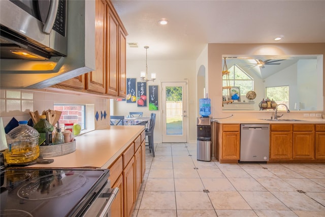 9434 Barretts Glen Ct, Houston, TX 77065 - kitchen with stainless steel appliances, a chandelier, brown cabinets, light countertops, and recessed lighting