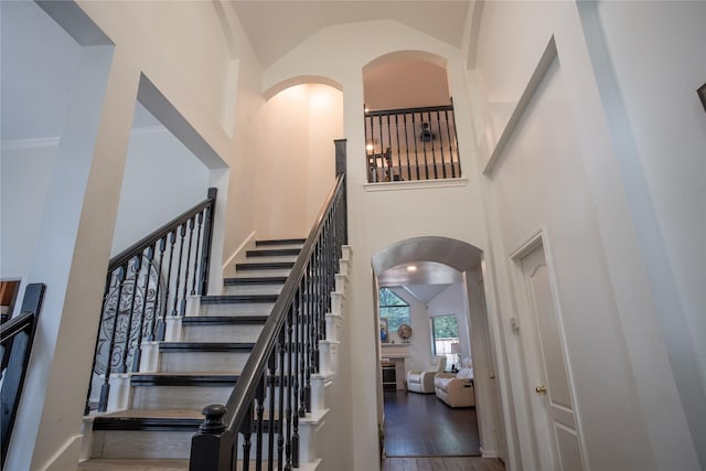9434 Barretts Glen Ct, Houston, TX 77065 - stairway with high vaulted ceiling, arched walkways, and wood finished floors