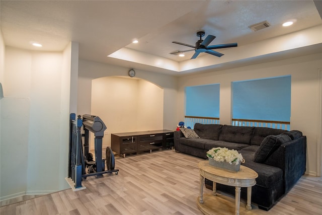 9434 Barretts Glen Ct, Houston, TX 77065 - living room with light wood-style floors, a ceiling fan, arched walkways, a tray ceiling, and recessed lighting