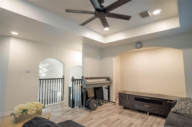 9434 Barretts Glen Ct, Houston, TX 77065 - living area featuring arched walkways, ceiling fan, light wood-style flooring, a raised ceiling, and recessed lighting