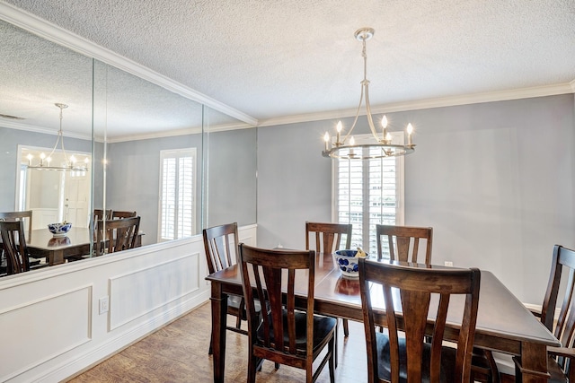 1109 Cheshire Ln, Houston, TX 77018 - dining room with a chandelier, a textured ceiling, crown molding, wainscoting, and wood finished floors