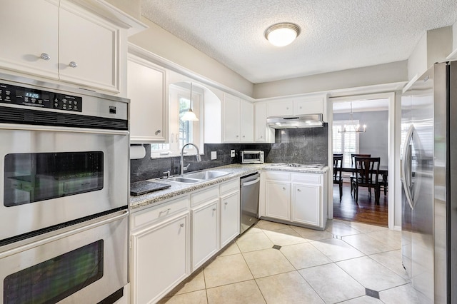 1109 Cheshire Ln, Houston, TX 77018 - kitchen with stainless steel appliances, healthy amount of natural light, under cabinet range hood, backsplash, and a textured ceiling