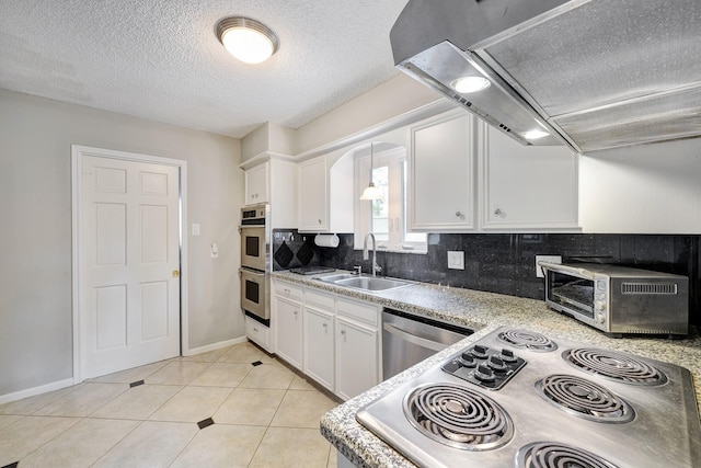 1109 Cheshire Ln, Houston, TX 77018 - kitchen with ventilation hood, stainless steel appliances, white cabinetry, decorative backsplash, and a textured ceiling