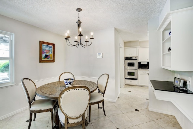 1109 Cheshire Ln, Houston, TX 77018 - dining space featuring a chandelier, a textured ceiling, light tile patterned floors, and a wainscoted wall