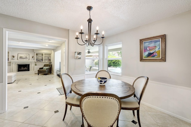1109 Cheshire Ln, Houston, TX 77018 - dining room featuring a chandelier, a wainscoted wall, built in features, a textured ceiling, and light tile patterned floors