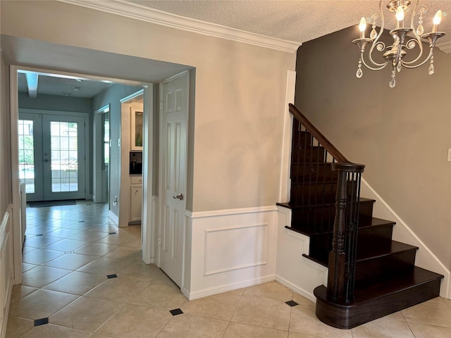 1109 Cheshire Ln, Houston, TX 77018 - staircase with a chandelier, wainscoting, tile patterned flooring, a textured ceiling, and ornamental molding