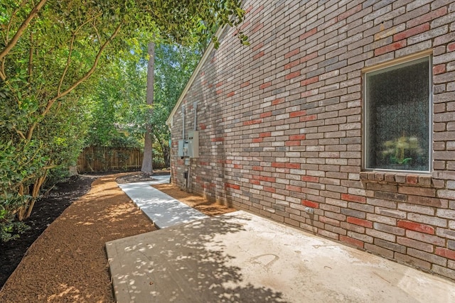 163 W Village Knoll Cir, The Woodlands, TX 77381 - view of property exterior featuring brick siding and a patio area