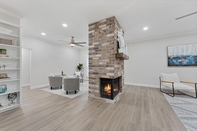 163 W Village Knoll Cir, The Woodlands, TX 77381 - living room featuring ceiling fan, a brick fireplace, light wood-style flooring, crown molding, and recessed lighting