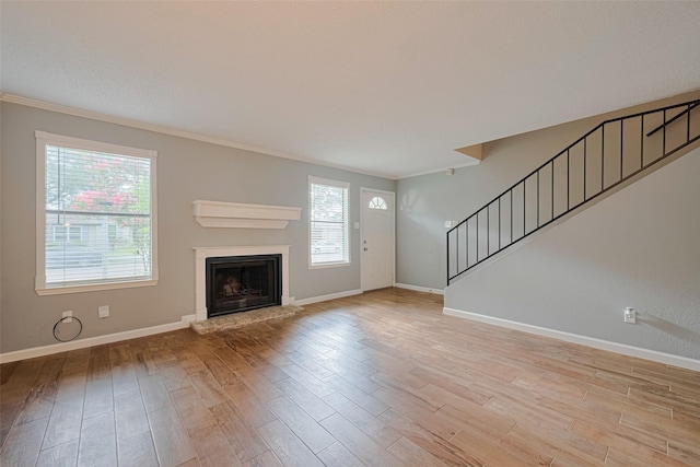 6452 Kentwick Dr, Houston, TX 77084 - unfurnished living room featuring stairs, light wood finished floors, crown molding, and a fireplace with raised hearth