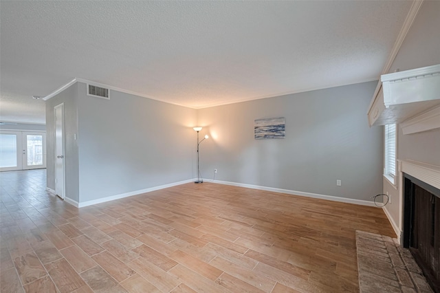 6452 Kentwick Dr, Houston, TX 77084 - unfurnished living room with crown molding, a fireplace, light wood-type flooring, and a textured ceiling
