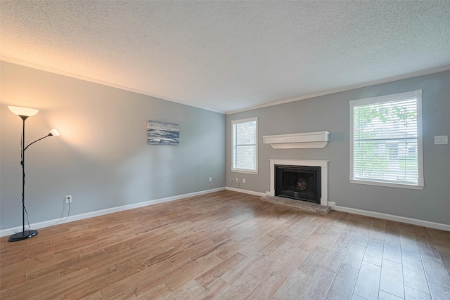 6452 Kentwick Dr, Houston, TX 77084 - unfurnished living room featuring ornamental molding, wood finished floors, a textured ceiling, and a fireplace with raised hearth