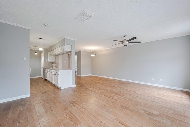 6452 Kentwick Dr, Houston, TX 77084 - unfurnished living room featuring a ceiling fan, ornamental molding, light wood-type flooring, and a textured ceiling