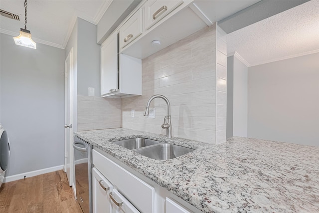 6452 Kentwick Dr, Houston, TX 77084 - kitchen featuring ornamental molding, white cabinets, tasteful backsplash, light stone counters, and light wood finished floors
