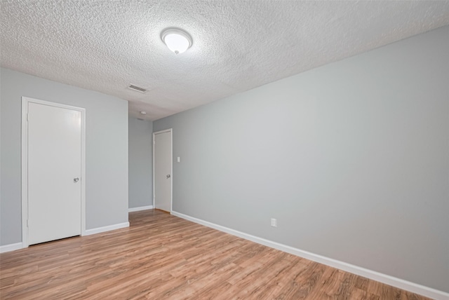 6452 Kentwick Dr, Houston, TX 77084 - unfurnished bedroom with light wood-type flooring and a textured ceiling