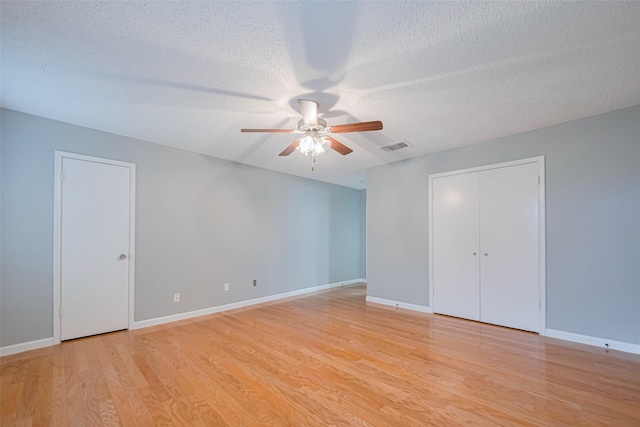 6452 Kentwick Dr, Houston, TX 77084 - unfurnished bedroom featuring light wood-style flooring, a textured ceiling, and a ceiling fan