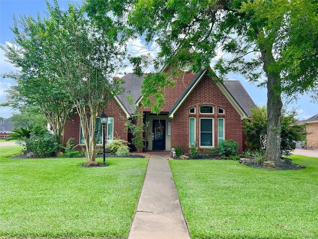 51 S Trillium Ct, Lake Jackson, TX 77566 - view of front facade featuring brick siding, a front yard, and a shingled roof