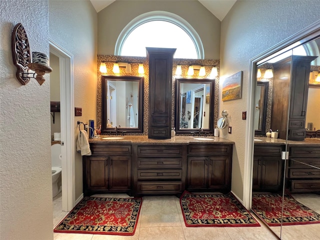 51 S Trillium Ct, Lake Jackson, TX 77566 - full bathroom with a textured wall, double vanity, lofted ceiling, and tile patterned floors